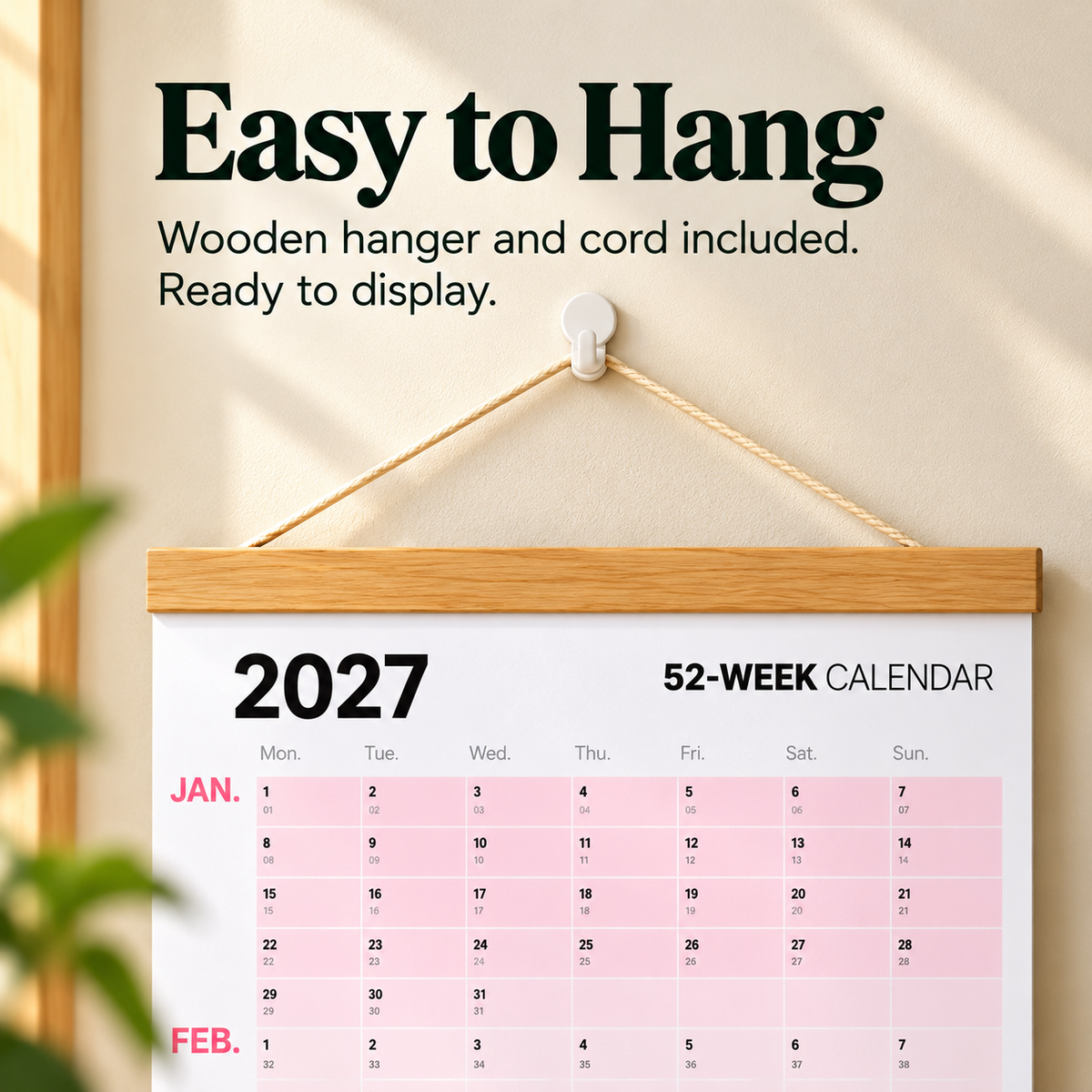 Wall calendar hanging from natural wooden top rail and cord with wood bottom rail